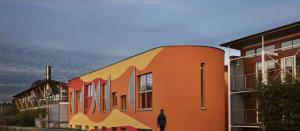 Roadside image of the Innovation Studio, a bold design painted in bright orange