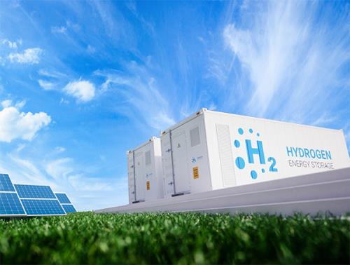 A field with solar panels and large white containers for an electrolyser to generate green hydrogen fuel