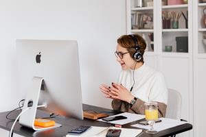 Business woman wearing headphones at desk on a video conference
