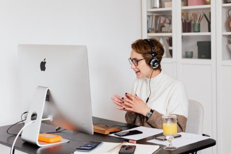 Business woman wearing headphones at desk on a video conference